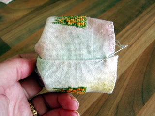 Sewing the seams to close the tin.